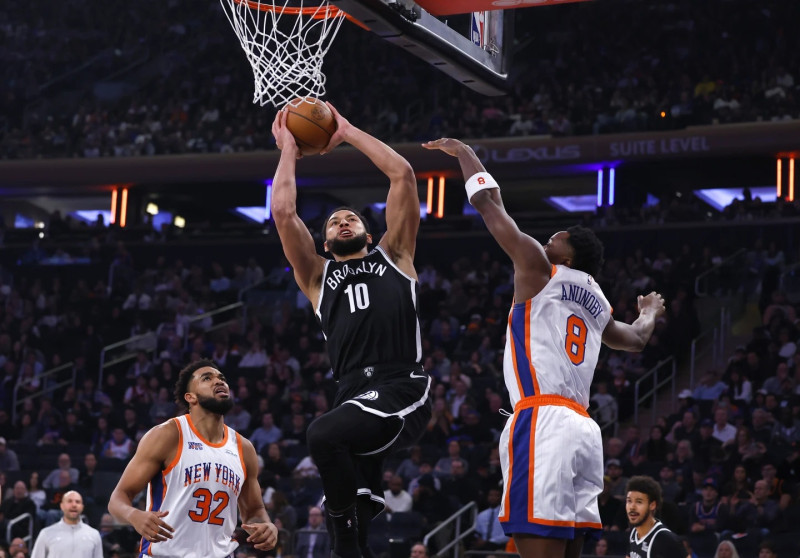 Three players battle for basketball