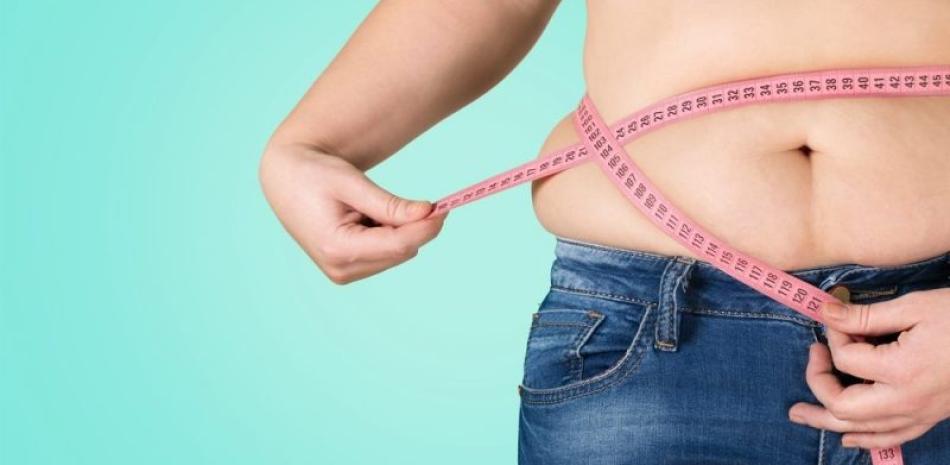 Woman using tape measure on waist