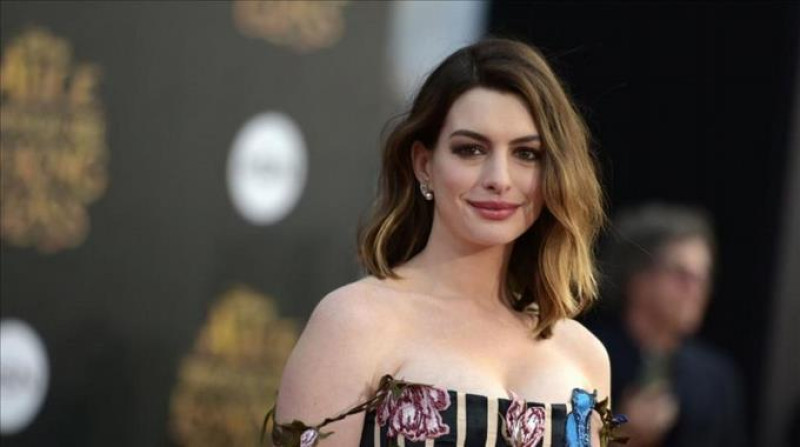 Anne Hathaway sonriendo en vestido blanco