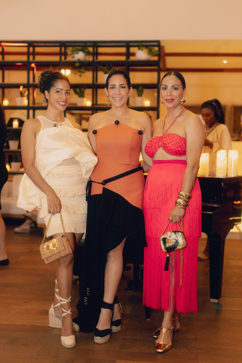 Tres mujeres elegantes en evento formal