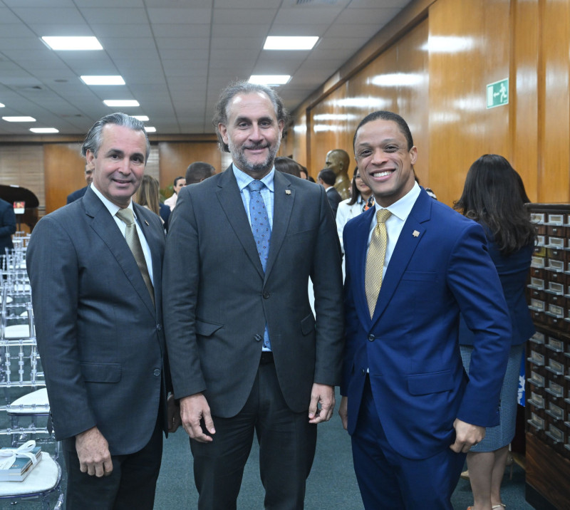 Tres hombres con traje posando formalmente