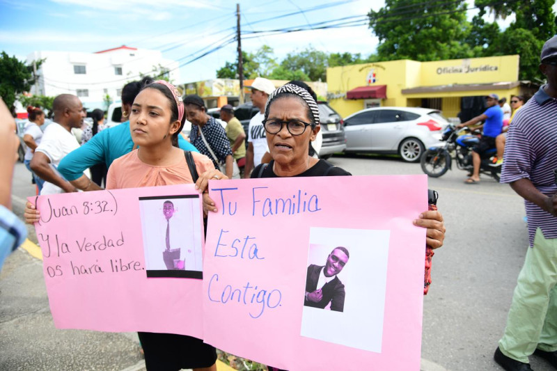 Manifestantes con pancarta rosada