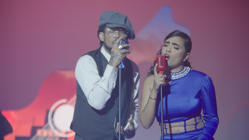 Pareja cantando en escenario rojo