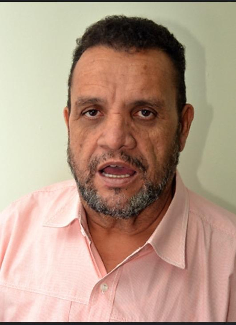 Hombre sonriente con camisa rosada