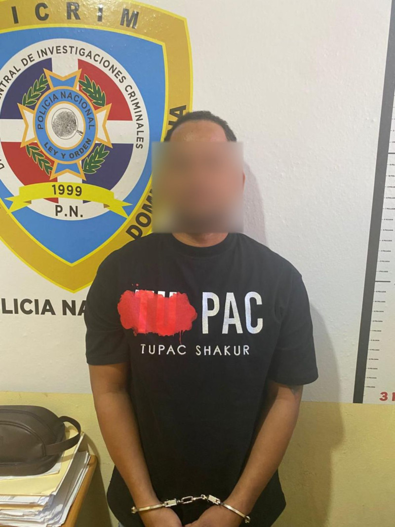 Hombre esposado frente a policía