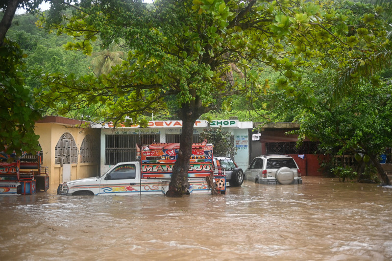 Calle inundada con vehículos sumergidos