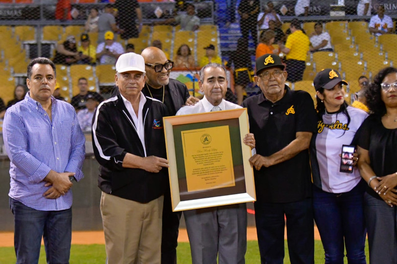 Personas sostienen premio enmarcado