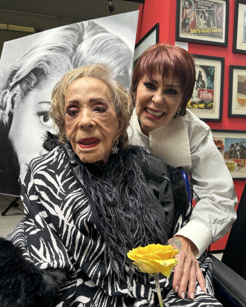 Dos mujeres observando una rosa amarilla