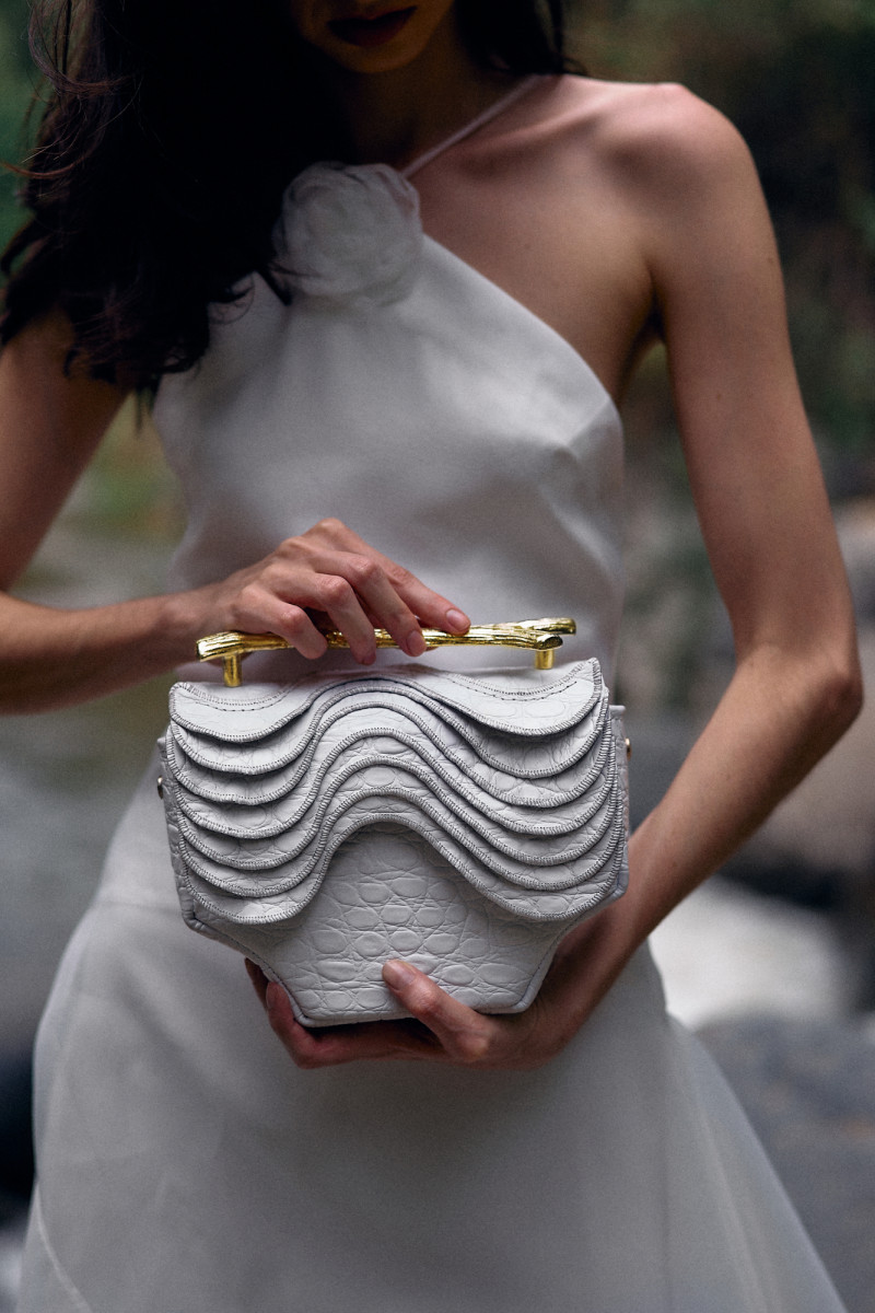 Mujer con bolso y atuendo blanco