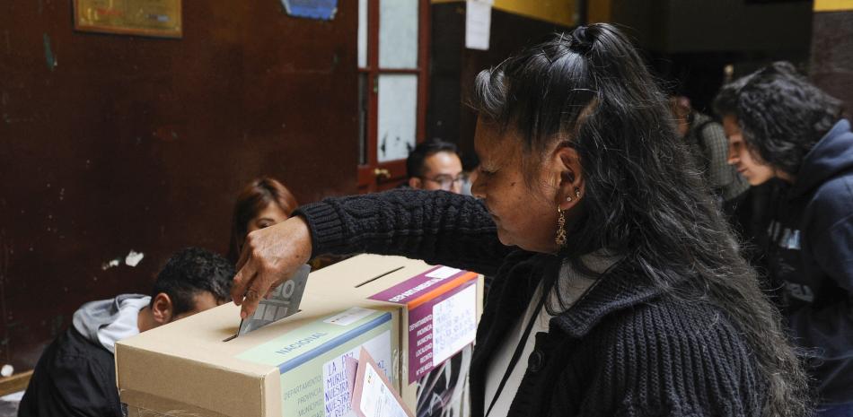 Mujer deposita voto en urna electoral