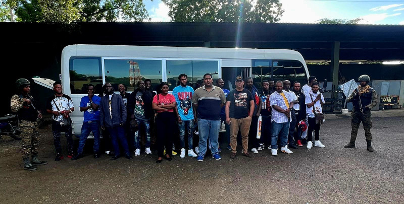 Hombres reunidos frente a un autobús