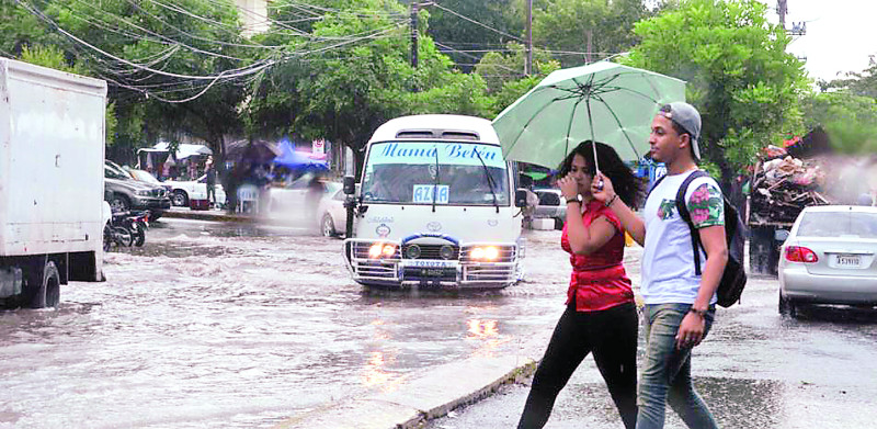 Personas caminando bajo lluvia torrencial