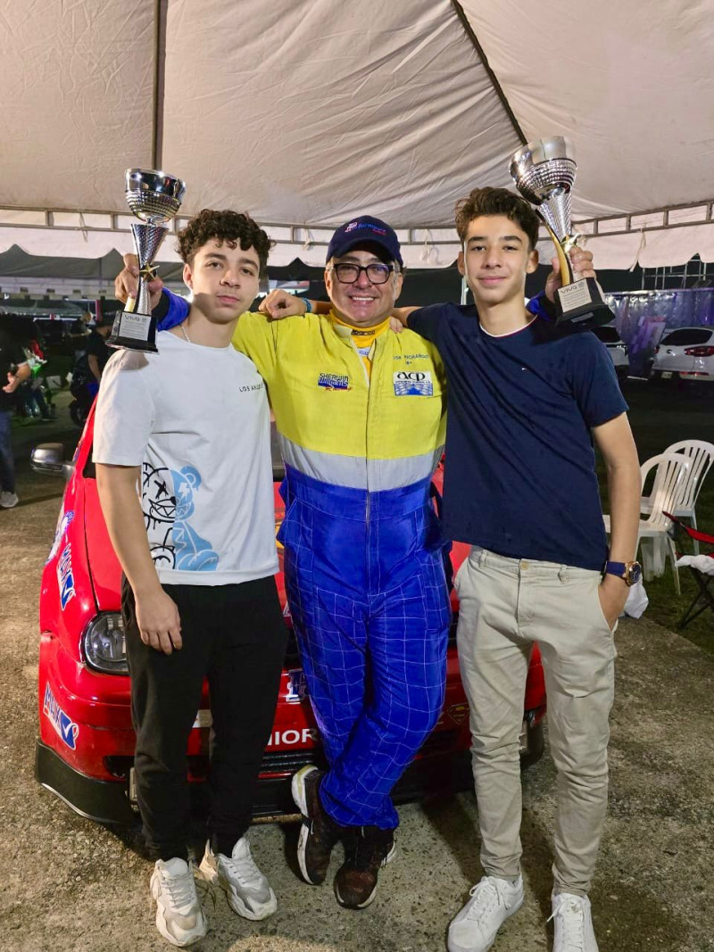 Tres pilotos con trofeos y auto