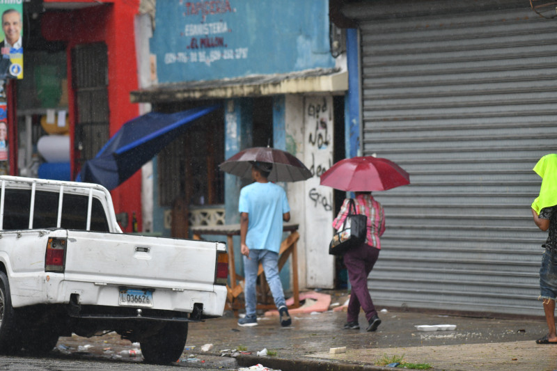 Personas caminando bajo lluvia intensa