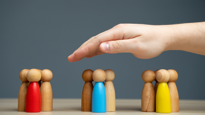 Mano sobre figuras humanas de madera