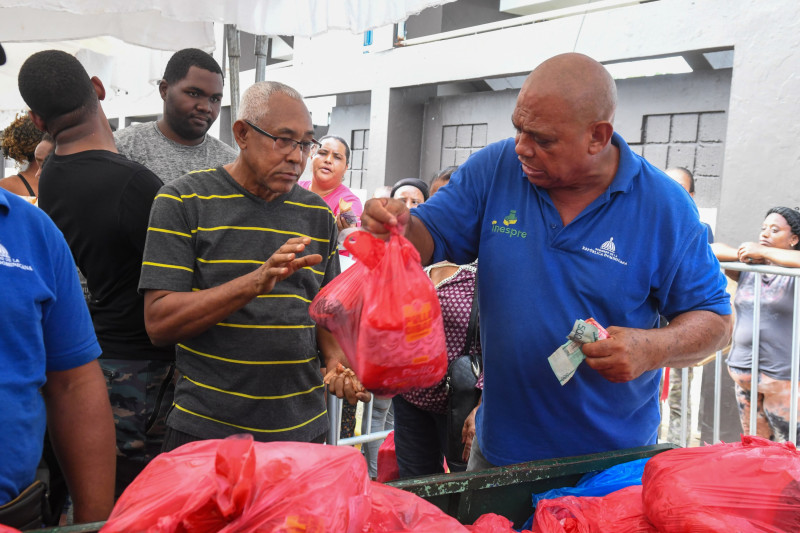 Hombre entrega bolsas rojas navideñas