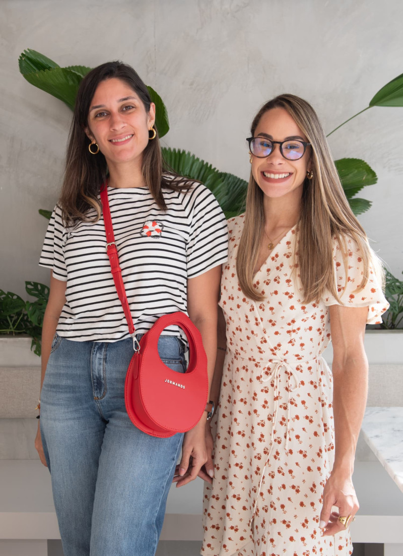 Dos mujeres sonríen en traje formal