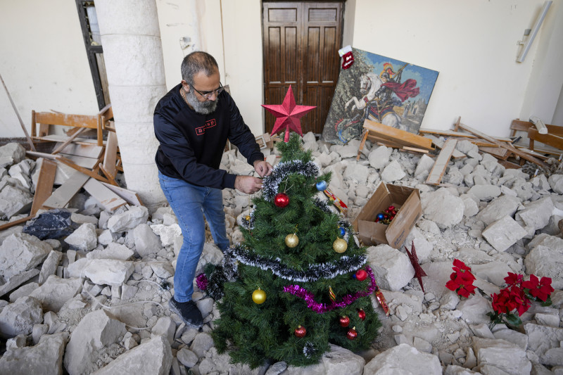 Hombre decora árbol navideño