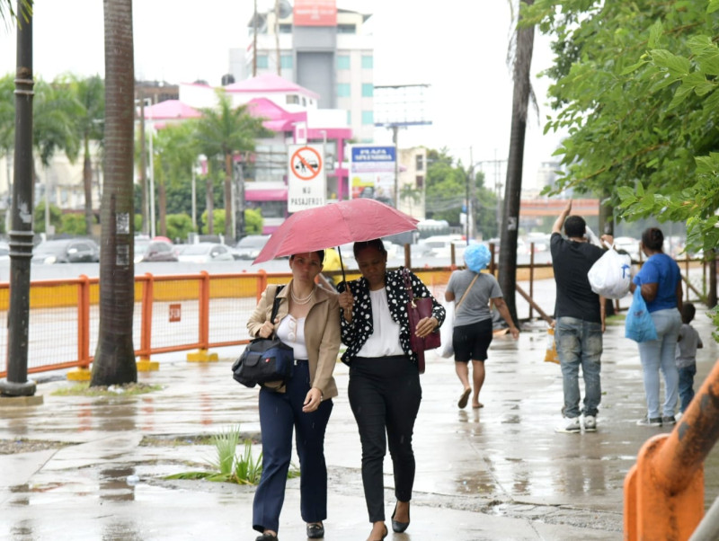 Mujeres caminan bajo la lluvia