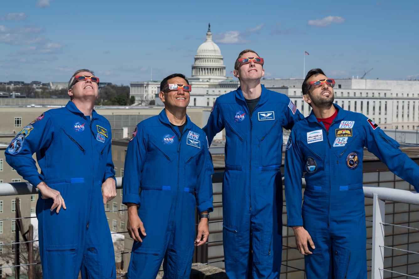 Cuatro astronautas en trajes espaciales azules