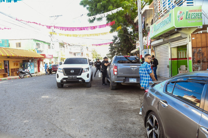 Personas junto a vehículos en calle