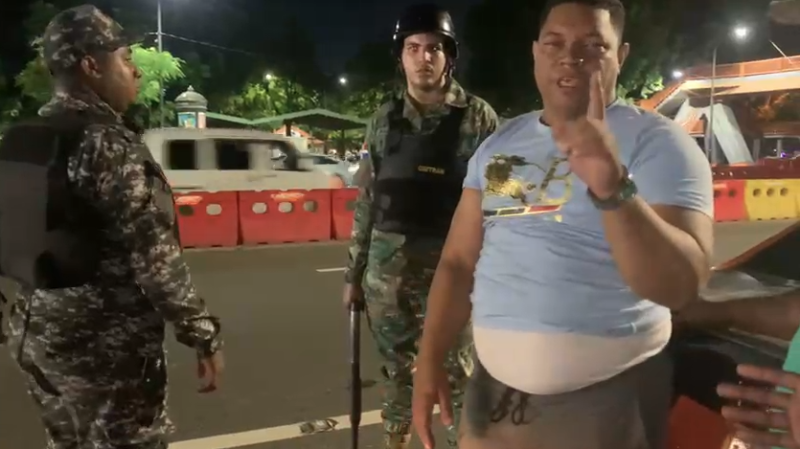 Hombre gesticulando en camisa azul