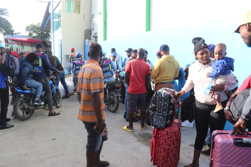 Pasajeros esperando con maletas en aeropuerto