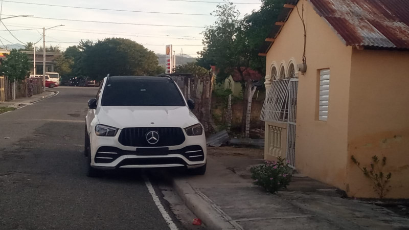 SUV Mercedes blanco estacionado en calle