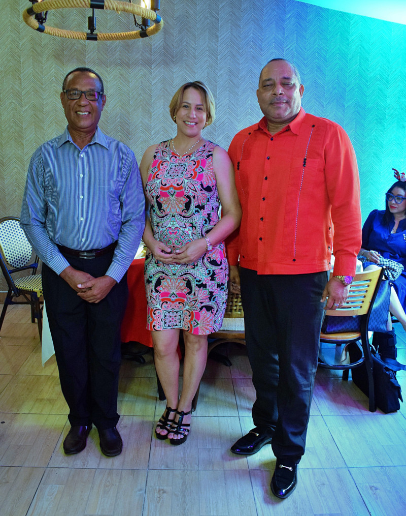 Tres personas posando en evento formal