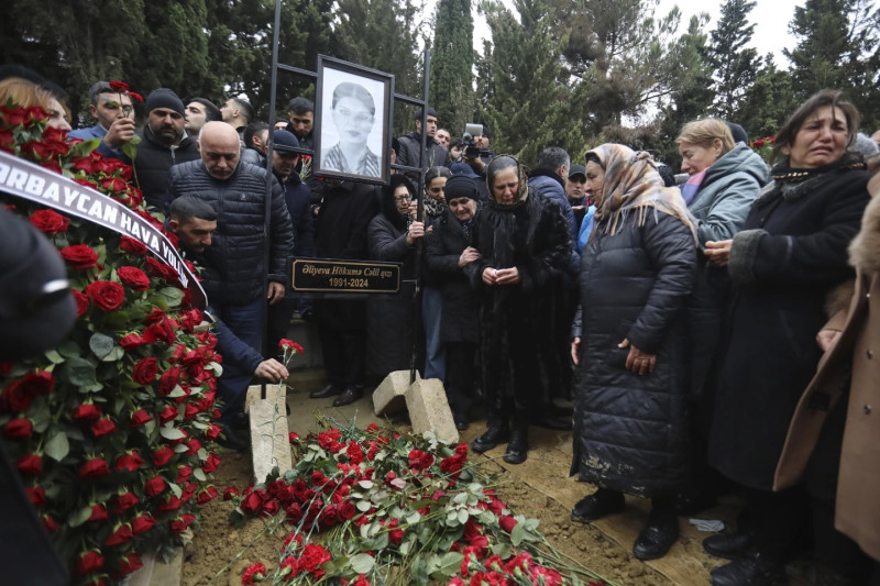 Personas reunidas en funeral con flores