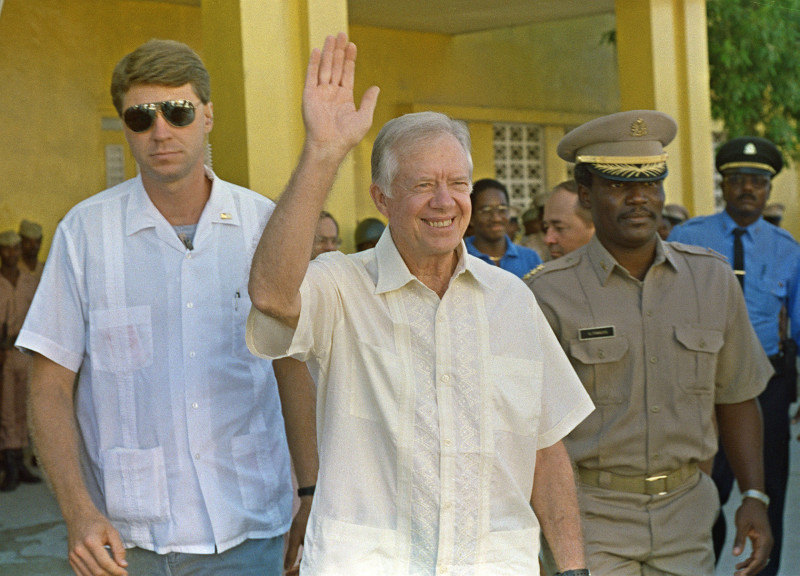 Hombre vestido de blanco sonriendo