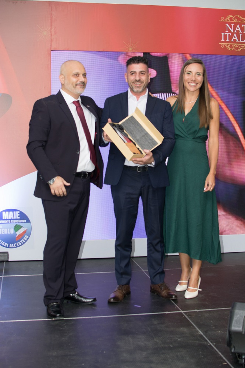 Tres personas sostienen premio editorial