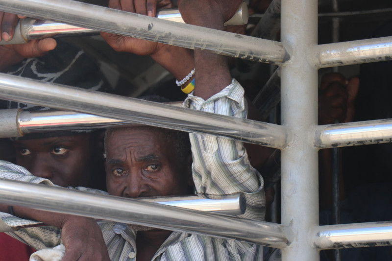 Migrantes detenidos tras rejas metálicas