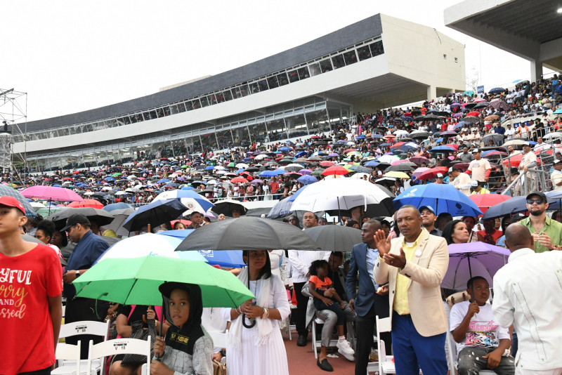 Multitud resguardada con paraguas en lluvia