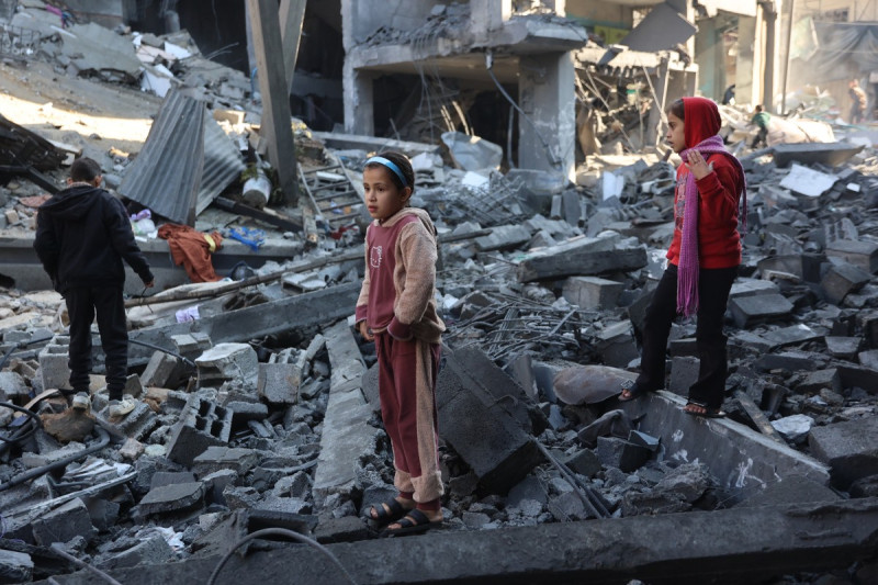 Contenido gráfico / Niños palestinos inspeccionan los daños en el sitio de un ataque israelí en el centro de la Franja de Gaza el 1 de enero de 2025.