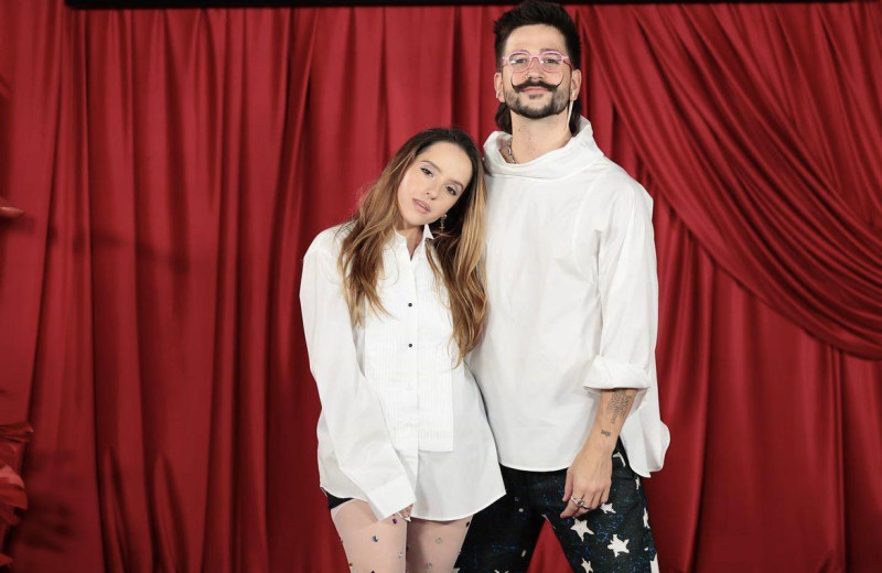 Dos personas frente a cortinas rojas