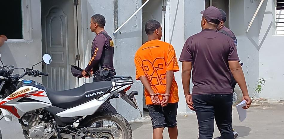 Hombre esposado escoltado por policías