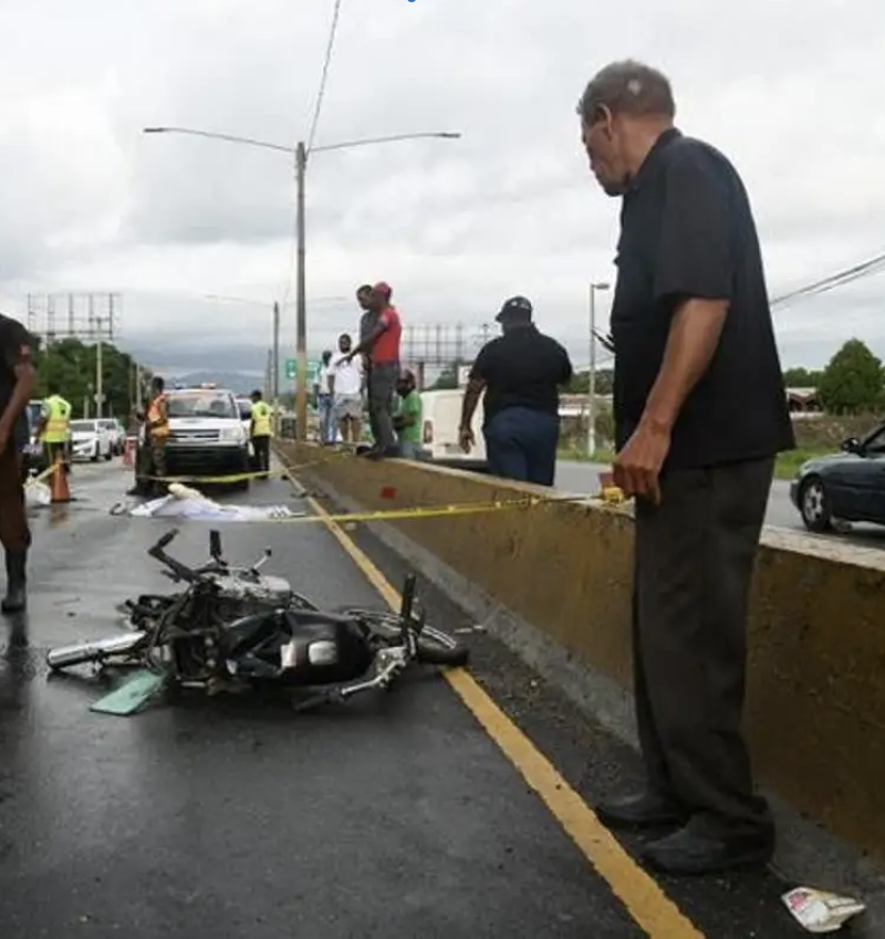 Hombre junto a motocicleta accidentada