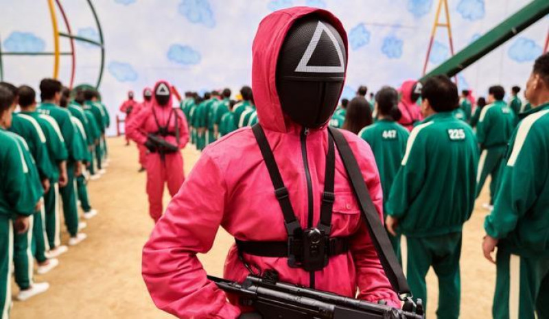 Soldado con traje rosa sostiene arma