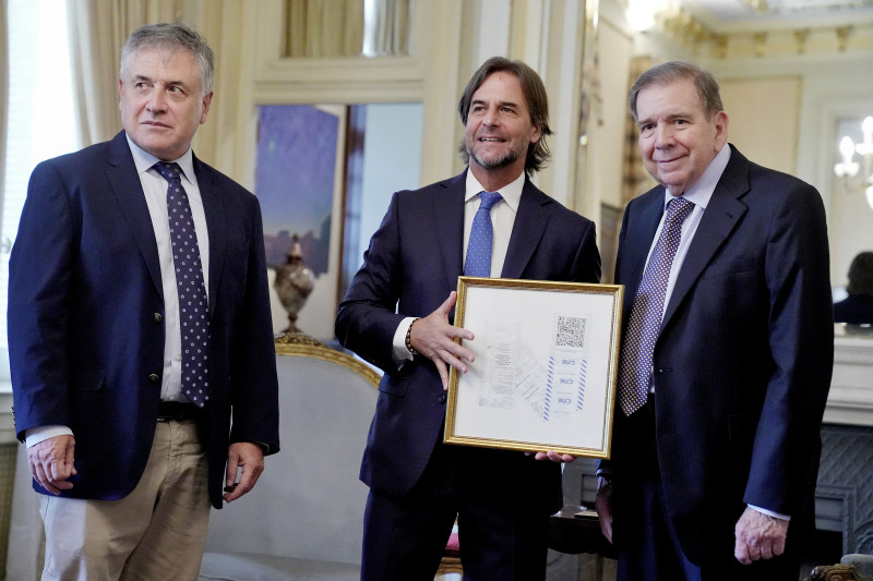 Tres hombres con premio enmarcado