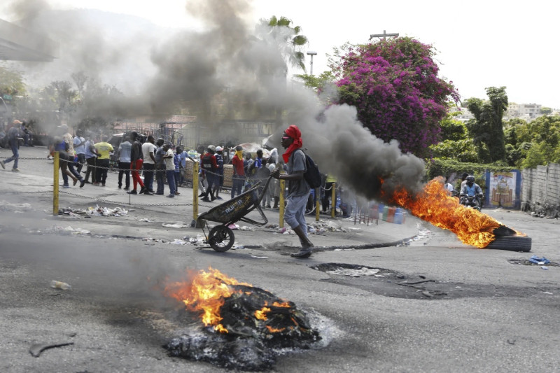 Manifestante empuja carretilla entre llamas