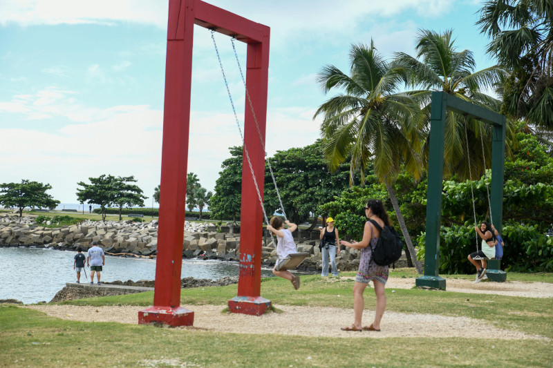 Niños en columpios junto al mar