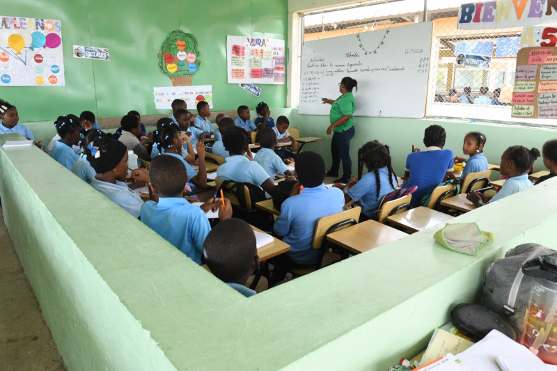 Estudiantes y docente en aula escolar