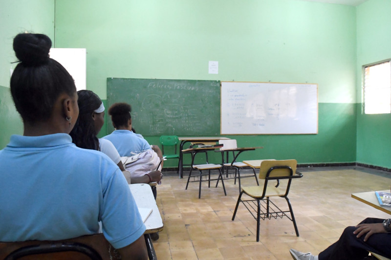 Estudiantes sentados en aula vacía