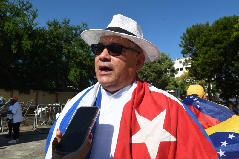 Hombre cubierto por banderas Cuba-Venezuela