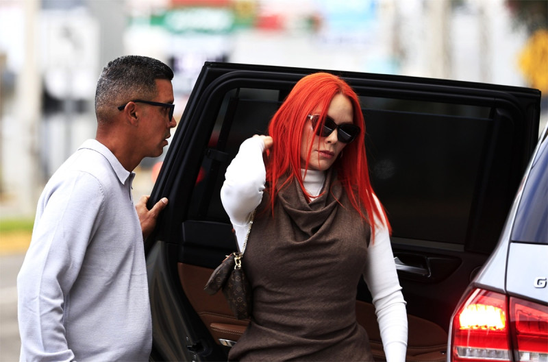 Mujer pelirroja saliendo del recinto