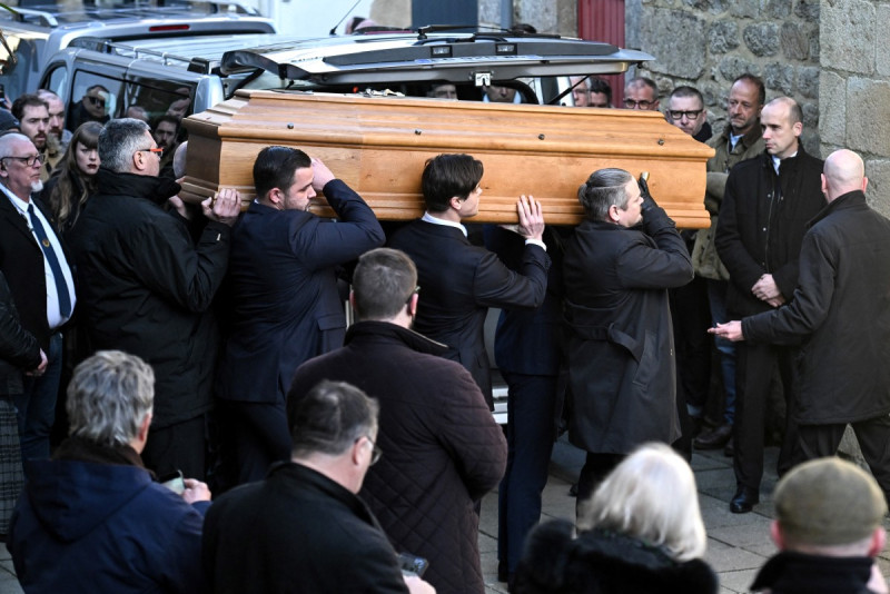 Hombres cargan ataúd en funeral