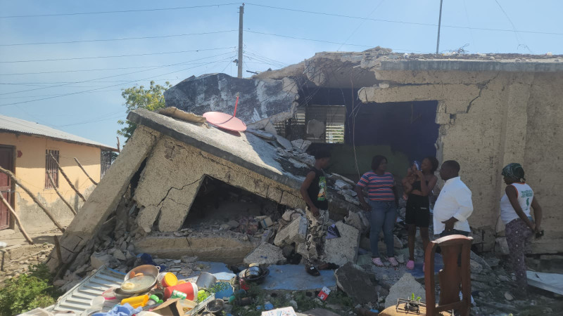 Edificio derrumbado con gente observando