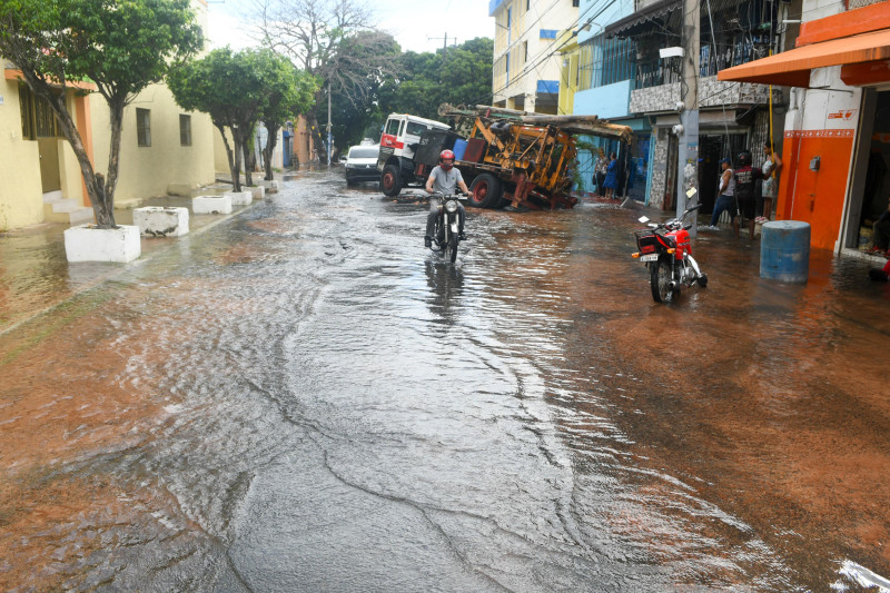 Motociclista cruza calle inundada