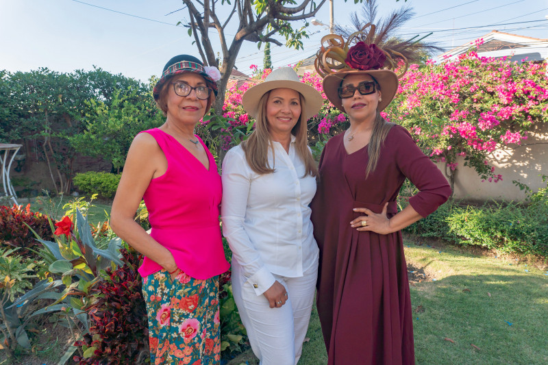 Tres mujeres con sombreros elegantes.